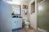 Charming bathroom with elegant vanity, plush decor, and a modern glass shower in a bright, airy space.