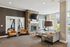 Inviting living room with rustic stone fireplace, modern furniture, and large windows offering natural light.