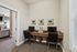 Elegantly designed home office nook with dual workstations, chic artwork, and warm natural lighting.