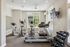 Bright and modern gym space with treadmills, elliptical machines, and a set of dumbbells, perfect for energizing workouts.