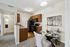 Charming kitchen and dining area with a granite countertop, sleek black appliances, and a cozy dining nook with elegant chairs and a glass-top table.