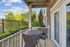 Charming balcony overlooking lush greenery, featuring a cozy outdoor table and chairs, perfect for relaxing moments.