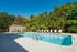 Inviting outdoor pool area with elegant lounge chairs surrounded by lush greenery, perfect for relaxation and recreation.