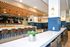 Inviting modern lounge area with chic wooden accents, plush seating, sleek countertops, and pendant lighting.