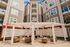 Modern apartment complex courtyard featuring stylish outdoor seating under a pergola, surrounded by multi-story contemporary buildings.