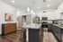 Modern kitchen design with sleek granite countertops, stainless steel appliances, and elegant pendant lighting. Features stylish white and dark cabinetry, contemporary decor, and a vibrant art piece. Spacious and inviting atmosphere.