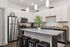 Modern kitchen design featuring sleek stainless steel appliances, granite countertops, and stylish pendant lighting over a spacious island with seating.
