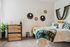 Cozy bedroom featuring modern wall decor, a sleek wooden dresser, and vibrant textiles for a stylish touch.