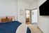Cozy bedroom with elegant decor, plush bedding, and a view into a modern bathroom, enhancing the apartment's inviting ambiance.