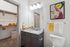 Modern bathroom with elegant granite countertop, vibrant art decor, and spacious walk-in closet.