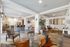 Elegant living space featuring stylish patterned chairs, a cozy seating area, modern kitchen with bar stools, and decorative lighting.