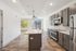 Sleek modern kitchen with stainless steel appliances, stylish gray cabinets, and a spacious island, bathed in natural light from large windows.