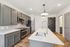 Modern kitchen featuring sleek gray cabinets, stainless steel appliances, and an elegant island with a stylish faucet.