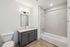 Contemporary bathroom with sleek vanity, elegant lighting, and spacious bathtub.