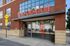 Inviting entrance to modern loft-style apartments at 'The Abigail' with eye-catching signage and brick facade, indicating studio to 2-bedroom leasing availability.
