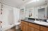 Bright and inviting bathroom with modern fixtures, wooden cabinetry, and tasteful beach-themed decor for a serene atmosphere.