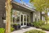 Inviting entrance of Trotters apartment complex with modern design, lush greenery, and vibrant flower arrangements.