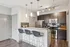 Modern kitchen with sleek granite countertops, stainless steel appliances, and stylish bar seating.