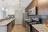 Elegant modern kitchen with granite countertops, stainless steel appliances, and chic dark wood cabinetry.
