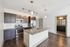 Modern kitchen with sleek dark cabinets, stainless steel appliances, and granite countertops, complemented by stylish lighting fixtures.