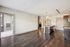 Modern open-concept kitchen and living area with sleek wood flooring and natural light from sliding doors leading to a private patio.