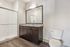 Modern bathroom with elegant granite countertop, large mirror, and sleek walk-in shower.