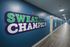 Vibrant exercise-themed hallway with motivational 'Sweat Like A Champion' sign, featuring sleek wooden flooring and modern blue walls.