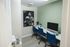 Chic modern home office with sleek computers, stylish blue chairs, and inspiring sports artwork.