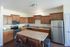 Warm and inviting kitchen featuring elegant wooden cabinetry, modern stainless steel appliances, and a spacious central island with seating.