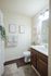 Charming and cozy bathroom with a modern vanity, soft lighting, and elegant wall art, creating a serene atmosphere.