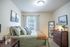 Inviting bedroom with cozy bed, modern decor, and ample natural light from a large window.