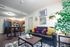 Chic open-plan living room and kitchen with modern decor, cozy seating, vibrant pillows, and elegant wood accents.