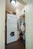 Stylish in-unit laundry room with stacked washer and dryer, wooden cabinetry, and convenient storage solutions.