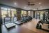 Modern apartment fitness center filled with state-of-the-art exercise equipment, including treadmills and elliptical machines, in a bright and spacious setting.