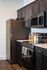 Modern kitchen with sleek dark cabinetry, stainless steel appliances, and stylish countertop storage jars.