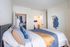 Inviting bedroom with cozy bedding, spacious open closet, and an en-suite bathroom, perfect for relaxation and comfort.