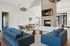 Elegant communal living space with modern sofas, stylish decor, a fireplace, and large windows for natural light.