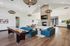 Chic and spacious apartment lounge featuring a modern fireplace, plush blue seating, a sleek shuffleboard table, and stylish pendant lighting.