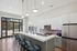 Modern kitchen with stainless steel appliances, a stylish island, and elegant pendant lighting overlooking a scenic patio view.