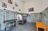 Bright and inviting pet grooming station with modern washing facilities, playful pet artwork, and vibrant orange seating accent.