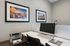 Modern home office with sleek desk setup, featuring a computer, printer, and vibrant cityscape photography.