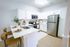 Modern kitchen with sleek stainless steel appliances, white cabinetry, and a chic breakfast bar with stylish stools.