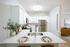 Elegant kitchen with modern stainless steel appliances, sleek white cabinetry, and an inviting breakfast bar set for two with stylish decor.