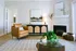 Chic living room featuring a cozy leather armchair, stylish artwork, and a modern fireplace for a warm, inviting ambiance.