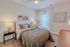Inviting bedroom with a cozy quilted bed, elegant nightstands, and contemporary wall art.