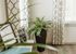 Bright corner with elegant curtains, stylish potted plant in sleek vase, and polished table for a cozy ambiance.