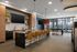 Elegant communal kitchen with sleek island seating, modern design elements, and abundant natural light streaming through large windows.