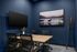 Contemporary conference room with elegant decor, featuring a sleek wooden table, modern chairs, and captivating moose artwork on a deep blue accent wall.