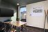 Modern meeting room with sleek table, stylish chairs, large flat-screen TV, and mountain sketch on the whiteboard. Bright natural light from the window creates an inviting atmosphere.