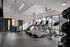 Modern gym with state-of-the-art treadmills, stationary bike, and large windows offering ample natural light.